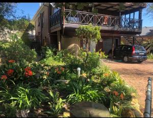 a garden in front of a house with a balcony at Coastal Cottage in Klein Brak Rivier