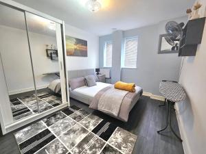 - une chambre avec un lit et un grand miroir dans l'établissement ABBA Views, à Londres
