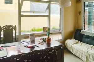 uma sala de estar com uma secretária e uma janela em Arwana Inn Lampung RedPartner em Bandar Lampung