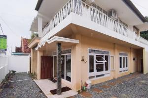 una casa construida con un balcón en la parte superior en Arwana Inn Lampung RedPartner en Bandar Lampung