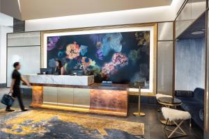 a lobby with a large painting of flowers on the wall at The Laura Hotel, Houston Downtown, Autograph Collection in Houston