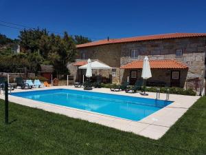 uma piscina em frente a uma casa em Casa Cachada em Braga