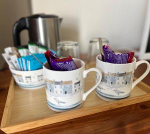 a group of three coffee cups sitting on a wooden tray at Bay View Guest House in Beer