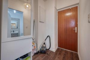 un couloir avec une porte et un aspirateur dans l'établissement Le Charreton 1 I Ile Verte / CHU de Grenoble, à Grenoble 11 autres photos
