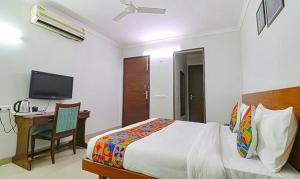 - une chambre avec un lit, un bureau et une télévision dans l'établissement TIPSYY INN 020, à Gurgaon