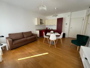uma sala de estar com um sofá, uma mesa e cadeiras em ROMOLO 24-TRIESTE CENTER em Trieste