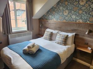 a hotel room with a bed with towels on it at The Oak Baginton in Coventry