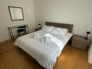 um quarto com uma cama branca e toalhas em ROMOLO 24-TRIESTE CENTER em Trieste