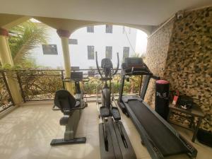 a gym with a treadmill and a swimming pool at Villa L'Oasis in Ouagadougou