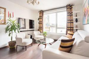 a living room with a white couch and chairs at Chambres privées, au cœur des sites olympiques in Saint-Denis