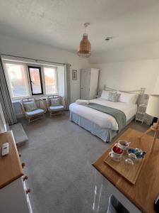 a bedroom with a bed and a table and chairs at Bay View Guest House in Beer