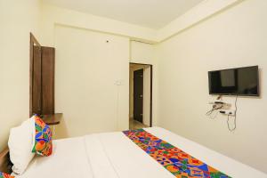 1 dormitorio con 1 cama y TV de pantalla plana en FabHotel Seva Service Apartment, en Nagpur