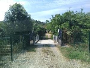 un camino de tierra con una valla y árboles en Les Près, en Villeneuve-Loubet