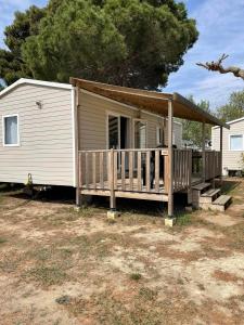 a mobile home with a porch and a deck at Charmant mobil-home premium 304 in Narbonne