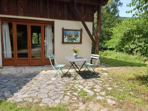 a table and two chairs in front of a house at Gite de Mailhac in Loubières