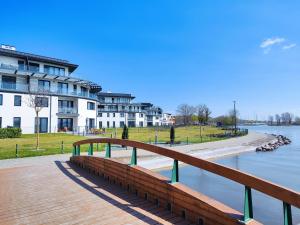 un pont en bois sur une rivière avec des bâtiments en arrière-plan dans l'établissement Royal Liberty Apartment, à Keszthely