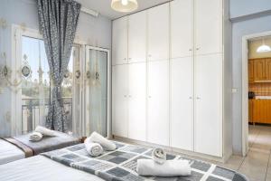 ein Schlafzimmer mit weißen Schränken und einem großen Fenster in der Unterkunft Zante's Azure Nest - Serene Summer Getaway in Ambelókipoi