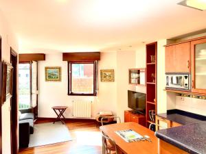 a kitchen with a living room with a table at Mundaka bihotzean con parking gratuito in Mundaka