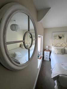 a bedroom with a large mirror on the wall at Bay View Guest House in Beer