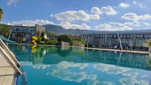 a pool of water in front of a building at 2 bedroom ground floor apartment in Kalogrea
