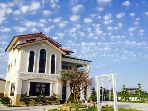 un edificio bianco con un cielo azzurro con nuvole di Sweetlight B&B a Jiaoxi