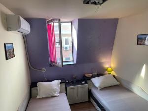 Habitación pequeña con 2 camas y ventana en Cloud 9 Hostel en Plovdiv