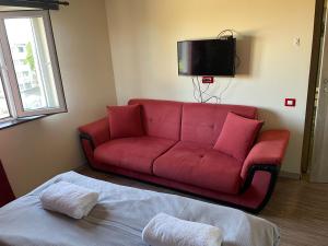 un sofá rojo en la sala de estar con TV en Cloud 9 Hostel en Plovdiv