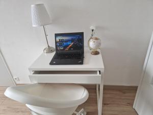 a white desk with a laptop computer on it at Studio confort in Fleury-les-Aubrais