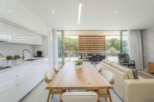 a kitchen and living room with a wooden table and chairs at Hopstays - Vila das Lagoas - Salgados in Albufeira