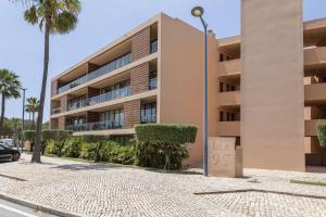 a building with a street light in front of it at Hopstays - Vila das Lagoas - Salgados in Albufeira