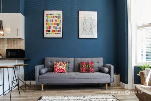 - un salon bleu avec un canapé gris et 2 oreillers dans l'établissement Super Unique 1 Bed Apart Bmouth, Free Parking - The Blue Bank Suite, à Bournemouth