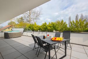 a table with a bowl of fruit on a balcony at Marina Apartman Balatonszemes by BLTN in Balatonszemes