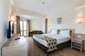 Cette chambre comprend un grand lit et un bureau. dans l'établissement Side Breeze Hotel, à Antalya
