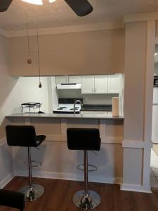 a kitchen with two bar stools in front of a counter at Blessing Home IN in Indianapolis