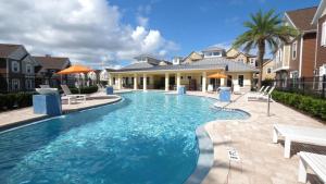 - une grande piscine dans une cour avec des maisons dans l'établissement Magical Themed House Just 5 Minutes to Disney Free BBQ Pool Access, à Orlando