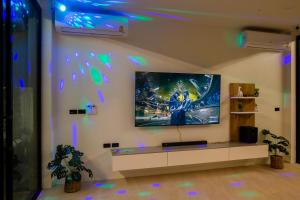 sala de estar con TV en la pared con luces en มาริลิน พูลวิลล่า ขนอม, 