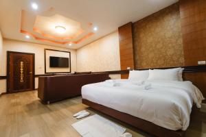 Habitación de hotel con cama grande y TV de pantalla plana. en The Crystal Ranong, en Ban Lum Than