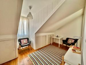 uma sala de estar com duas cadeiras e uma escada em Alcantara 2 Bedrooms Apartment em Lisboa