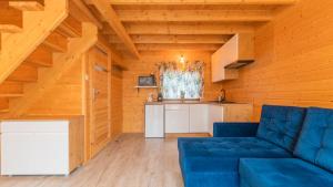 a living room with a blue couch and a kitchen at Nowodworska, Sun & Snow in Stegna
