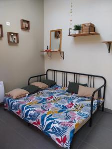 a bed with a colorful quilt on it in a room at le prieuré reposant in Notre-Dame de la Mer