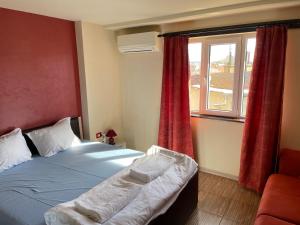 1 dormitorio con 1 cama y una ventana con cortinas rojas en Cloud 9 Hostel en Plovdiv