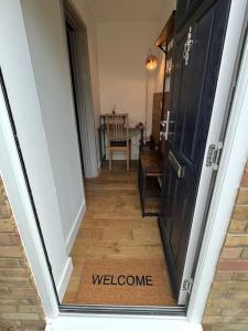 a hallway with a door with the word welcome at Luxurious Two-Bedroom Suite with Patio & EV power in Greenhithe