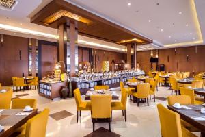 Gets Hotel Semarang في سيمارانغ: غرفة طعام مع طاولات وكراسي صفراء