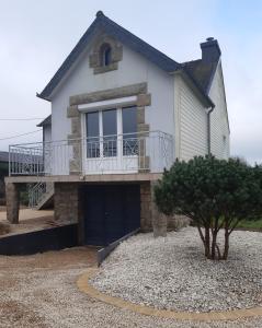 a house with a balcony and a garage at T'y louet in Carnoët