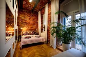 a room with a bed and a brick wall at RentPlanet - Nowa Papiernia in Wrocław