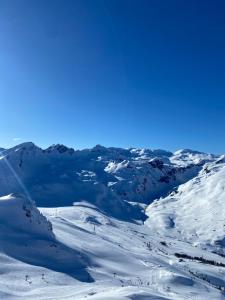 uma montanha coberta de neve com pessoas a esquiar nela em Chalet Epinel em Villaret