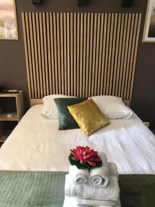 ein Bett mit Handtüchern und einer Blume darauf in der Unterkunft Appartement Romantique in Masevaux
