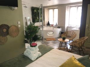 ein Schlafzimmer mit einem Bett und einer Badewanne sowie ein Badezimmer in der Unterkunft Appartement Romantique in Masevaux