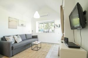 a living room with a couch and a flat screen tv at cozy & modern bungalow w/private garden bbq+wifi in Maspalomas