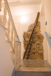 una escalera en una casa con una pared de piedra en DEMIVIE GUESTHOUSE en Lerici